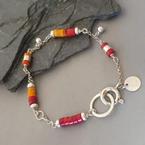 Kolorowa bransoletka ręcznie robiona z czerwonego i pomarańczowego koralu, z charmsami z koralików srebrnych, srebro próby 925